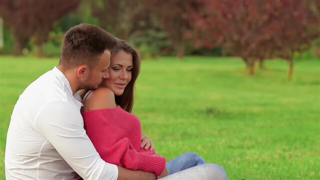 Joyful couple embracing on lush green grass