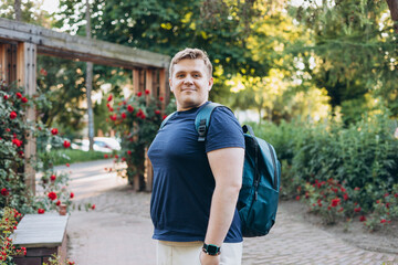Young happy smiling man walk in green city park outdoors on nature. Urban lifestyle leisure concept. High quality photo.
