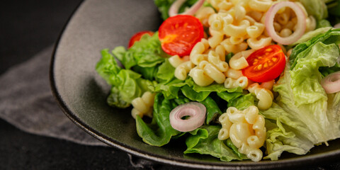 Pasta salad green leaf lettuce, tomato, pasta, onion fresh delicious gourmet food background on the table rustic food top view copy space keto and paleo diet vegan and vegetarian food