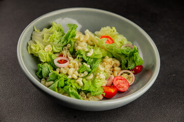 Pasta salad green leaf lettuce, tomato, pasta, onion fresh delicious gourmet food background on the table rustic food top view copy space keto and paleo diet vegan and vegetarian food