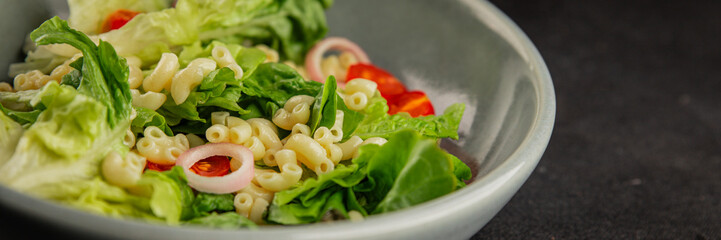Pasta salad green leaf lettuce, tomato, pasta, onion fresh delicious gourmet food background on the table rustic food top view copy space keto and paleo diet vegan and vegetarian food