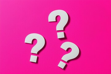 Three white question marks on vibrant fuchsia pink background. Concept for FAQ and inquiry.