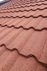 Textured brown roofing tiles arranged in a wavy pattern showcasing durable construction materials