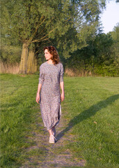 Woman Enjoying Nature in a Floral Dress in Park
