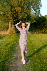Woman Enjoying Nature in a Floral Dress in Park