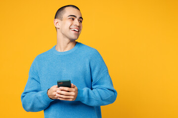 Young middle eastern man wearing blue sweatshirt casual clothes holding in hand use mobile cell...