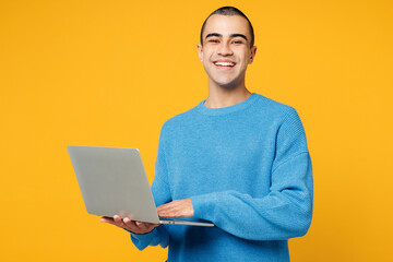 Young smart IT middle eastern man wearing blue sweatshirt casual clothes hold use work on laptop pc...