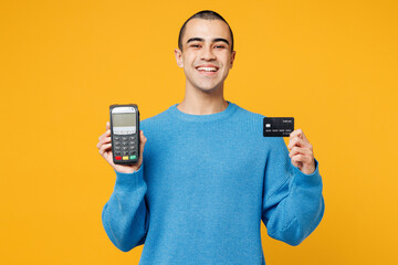 Young middle eastern man wearing blue sweatshirt casual clothes hold wireless modern bank payment...