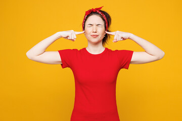 Young sad dissatisfied woman she wearing red t-shirt casual clothes cover ears with hands fingers...