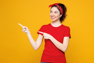 Young smiling happy fun woman she wear red t-shirt casual clothes point index finger aside indicate...