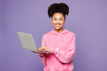 Young IT woman of African American ethnicity she wear pink hoodie casual clothes hold use work on...