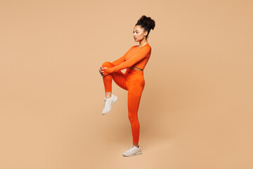 Full body side view young fitness trainer instructor sporty woman in orange clothes spend time in...