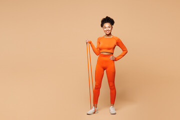 Full body young fitness trainer instructor sporty woman sportsman wearing orange clothes spend time...