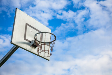 Naklejka premium Sunny day at the outdoor court with a basketball hoop against a blue sky