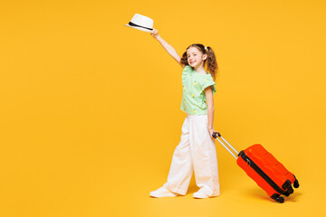 Traveler kid child girl she wear green casual clothes hold hat suitcase bag isolated on plain...