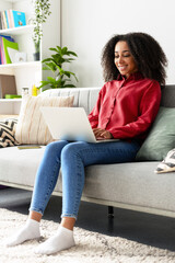 Professional African American employee, woman working from home on laptop smiling