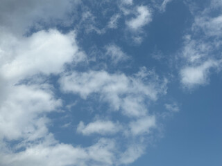 Natural view white clouds on soft blue sky background image. Sun shining through the puffy clouds.