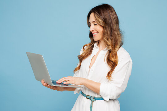 Side view young smart employee IT business woman corporate lawyer wear shirt classic formal clothes work in office hold use laptop pc computer isolated on pastel light blue background studio portrait.