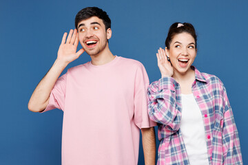 Young curious nosy couple two friends family man woman they wear pink casual clothes together try...