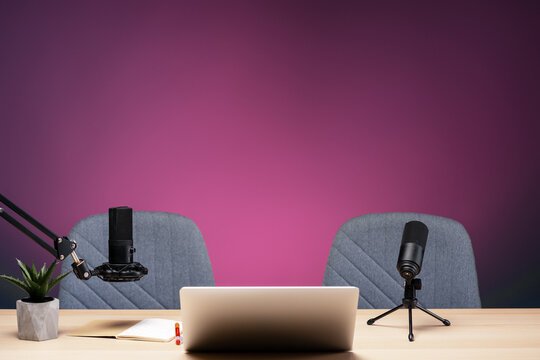 Podcast studio setup featuring microphones, laptop, and chairs ready for recording