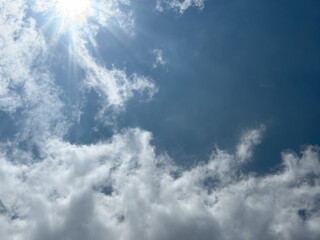 Natural view white clouds on soft blue sky background image. The beautiful clear sky with sun.