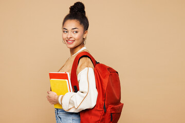 Side profile view young smiling teen girl student wear casual clothes backpack bag hold books look...
