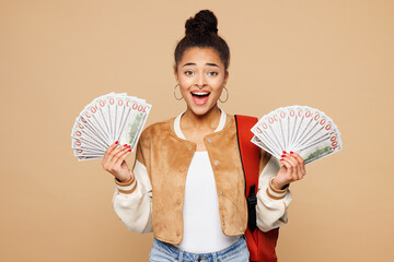 Young surprised girl student wear casual clothes backpack bag hold in hand fan of cash money in...