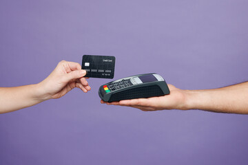 Close up cropped delivery courier male holding in hand modern bank payment terminal to process acquire credit card isolated on plain purple background. Service concept. Copy space advertising mock up.