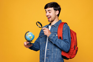 Side view young shocked boy student he wear denim casual clothes backpack bag hold globe Earth map...