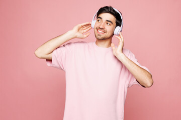 Young Caucasian man he wearing t-shirt casual clothes listen to music in headphones enjoy look...
