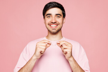 Young smiling happy man wears t-shirt casual clothes hold in hand invisible transparent aligners,...