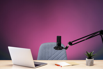 Professional microphone, laptop, and notebook on a desk preparing for recording
