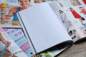 Different trendy magazines on wooden table, closeup