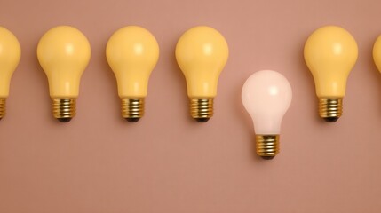 A row of yellow light bulbs with one white light bulb standing out against a brown background.