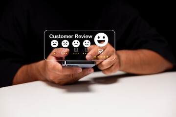 A person using a smartphone to select a positive five-star customer review with happy emoticons hovering above the device.