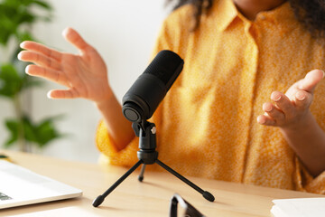 Radio host speaking into a microphone and gesturing with hands selective focus