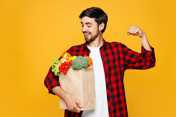 Young man wearing casual clothes hold paper bag for takeaway mock up with food products do winner...