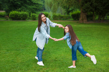 Fototapeta premium Family getaway. Happy mother and daughter spending time together in park