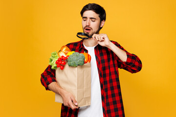 Young sad man he wearing casual clothes hold craft paper bag for takeaway mock up with food...