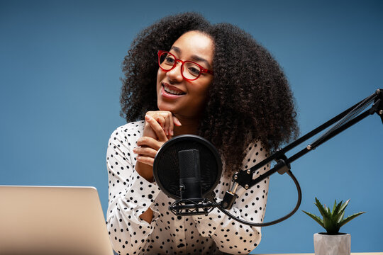 Young African American woman recording podcast in her home studio