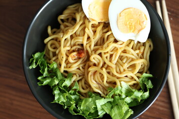 Japanese ramen with egg on black bowl in close-up