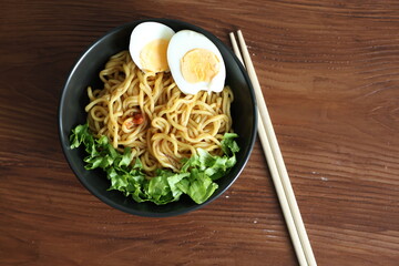 Japanese ramen with egg on black bowl in close-up