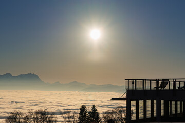 Sunrise over a sea of fog with terrace and mountain silhouette