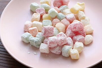 mini colors Turkish delights with roses on a white plate	