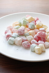 mini colors Turkish delights with roses on a white plate	