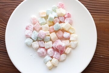 mini colors Turkish delights with roses on a white plate	