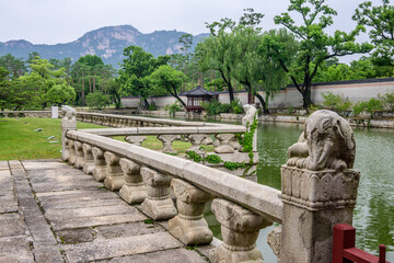 Pond pavilion within Gyeongbokgung Palace. This pond is part of the secret garden. Stone figures...