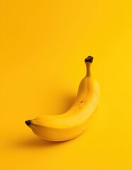 Single ripe banana on vibrant yellow backdrop, yellow fruit, yellow
