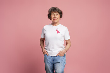 Senior woman wearing pink ribbon supporting breast cancer awareness