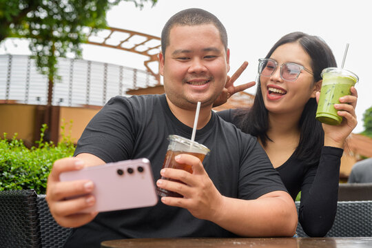 Happy couple sitting together in outdoors cafe restaurant during summer